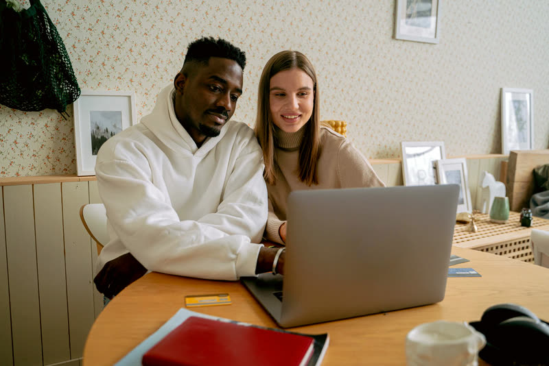 A couple picking out a big item together on a laptop