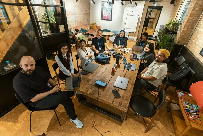 A diverse team gathered around a table in a modern coworking space