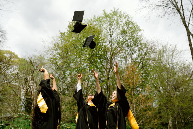 Graduates tossing their caps into the air together