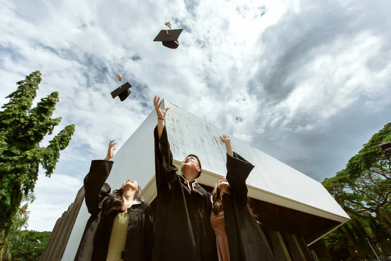 Graduates throwing their mortarboards in celebration