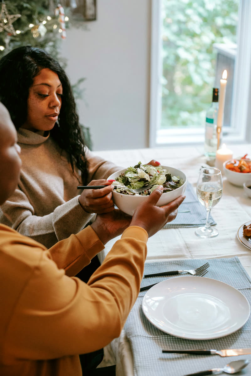 A dish passed hand to hand across a warm holiday table