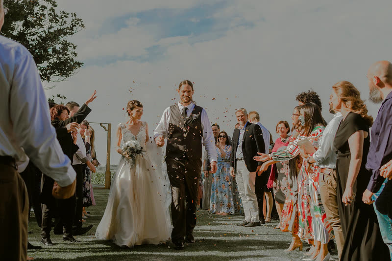 Wedding guests tossing confetti over the newlyweds