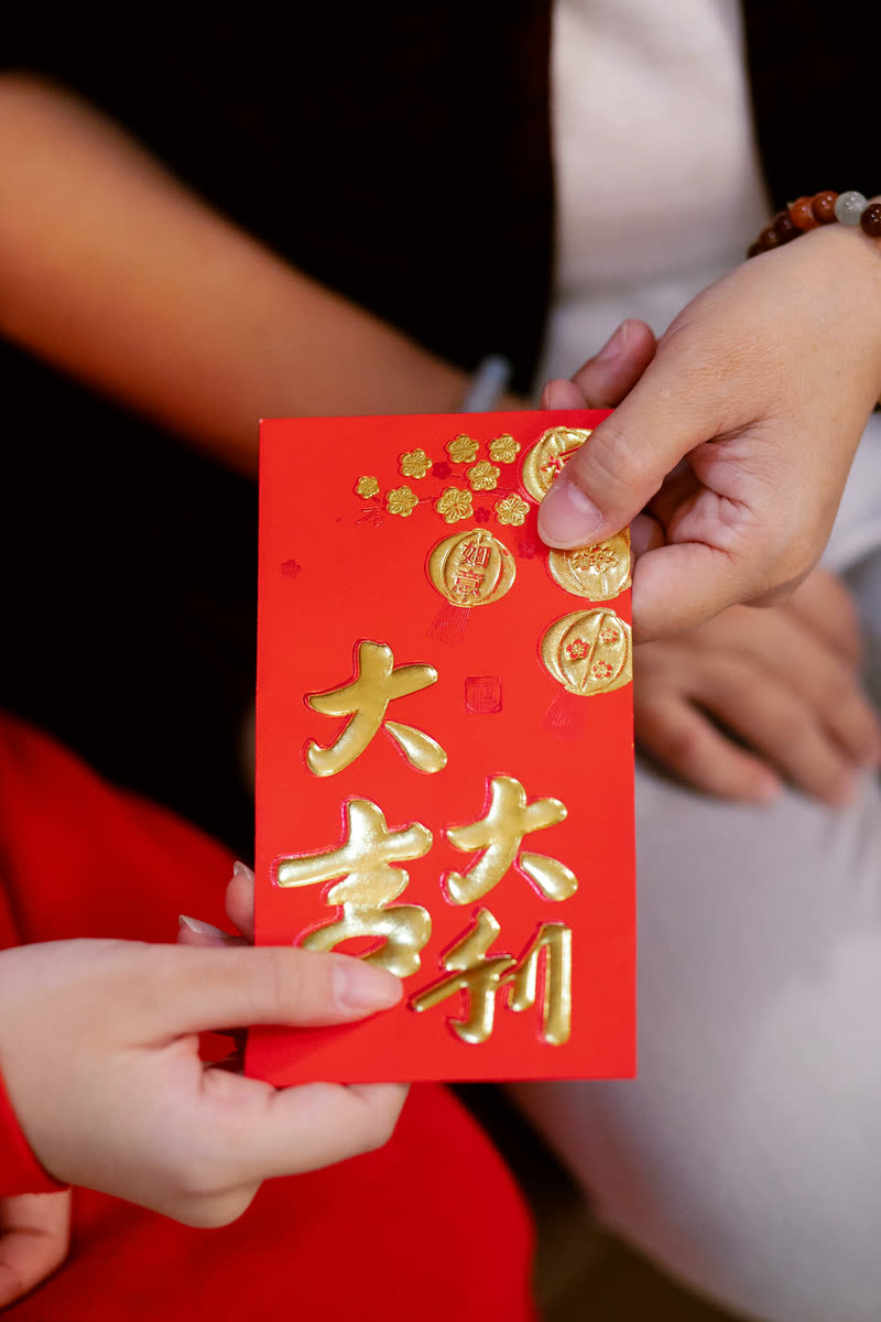 A guest passing a gift envelope at a celebration